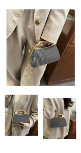 Detail of a black rhinestone clutch featuring gold circular handles and a metal chain strap