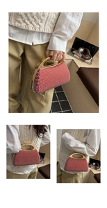 Detailed view of luxury red beaded evening clutch with gold metal handle and chain strap