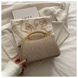 Detailed macro view of gold chain bag with rivet accents and metallic curved handle