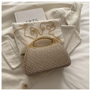 Close-up of sparkling rhinestone handbag with gold metal handle and chain strap