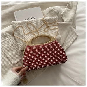 Close-up of luxury red rhinestone evening bag with gold handle and chain strap