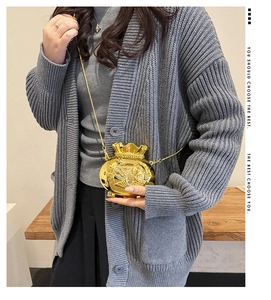 Detail view of mini gold fortune bag crossbody with embossed koi pattern and chain