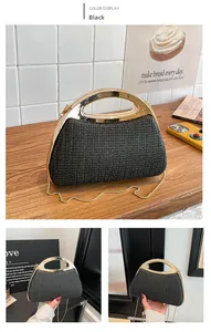 Detail van zwarte rieten tas met gouden metalen handvat en een verfijnde kettingriem