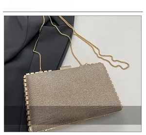 Close-up of champagne gold glitter evening box bag with fine beaded metal chain strap