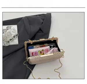 Detail showing the internal storage capacity of a gold clutch bag with a phone and wallet