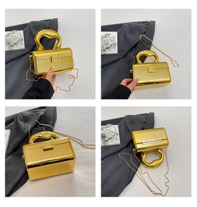 Detailed views of gold acrylic box bag with curved top handle and metal chain strap