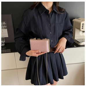 Detailed view of a pink sequin evening clutch bag with golden chain and metal clasp