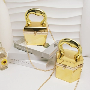 Makroaufnahme geometrischer goldener Acryl-Clutches mit klobigen Metallgriffen