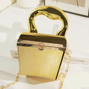 Detail der goldenen Acryl-Abendtasche mit strukturiertem Griff und Kettenriemen