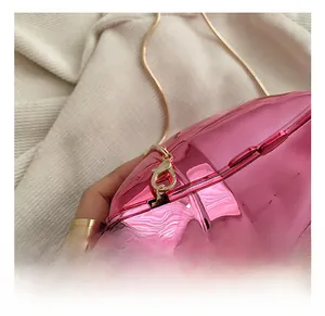 Detail of high-quality gold metal chain strap and hook on a pink metallic evening bag