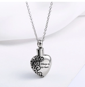 Detail of gold heart urn necklace with vine pattern and Always in my heart engraving