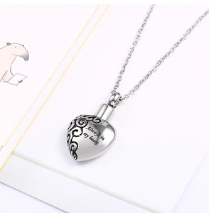 Macro detail of heart-shaped urn necklace with Always in my heart engraving