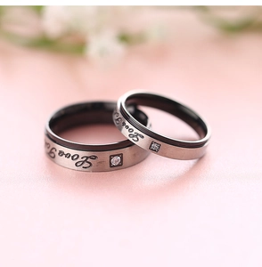 Makroaufnahme der silber-schwarzen gebürsteten Ringe mit Love Forever Gravur und Diamant