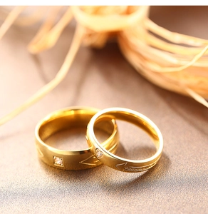 Makro-Detail goldener Partnerringe mit Diamant und 'YOU ARE MY ONLY' Gravur