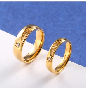 Détail de bagues de couple dorées avec motifs latéraux et zircons étincelants