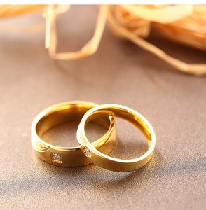 Gros plan sur un ensemble de bagues de couple en acier doré avec zircon carré et rond