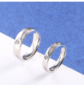 Détail macro de bagues de couple en acier titane argenté avec texture plume et diamant