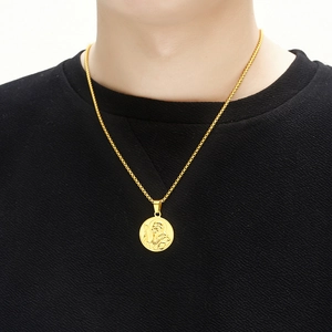 Gold St. Christopher religious medal pendant with box chain worn on black t-shirt