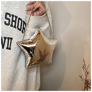 Macro shot of silver star-shaped crossbody bag with reflective mirror finish and chain strap