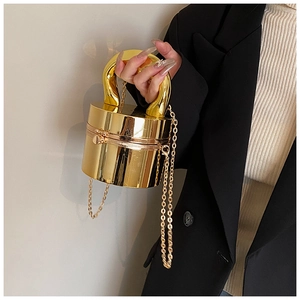 Close-up of golden cylindrical acrylic box bag with U-shaped handle and metal chain
