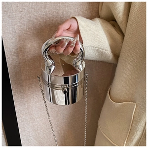 Close-up of a silver mirror cylinder handbag with metal chain and glossy finish