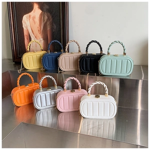 Collection of vibrant mini square handbags in nine colors on a silver display stand