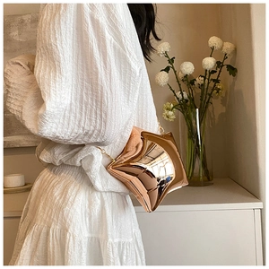 Detail shot of a star-shaped gold crossbody bag featuring a shiny mirror finish and chain