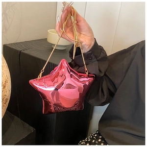 Detail of pink metallic star-shaped clutch bag with elegant gold chain strap