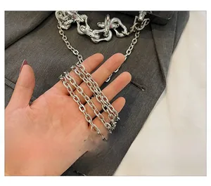 Close-up of polished silver metal chain strap with multi-link design on grey fabric
