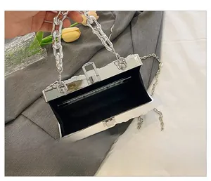 Silver metallic box bag with black velvet lining and detachable chain straps shown inside