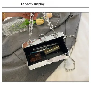 Detail showing internal capacity of the silver mirror box bag with wave-edge design