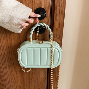 Chic mint green oval crossbody bag with quilted vertical texture and gold chain strap