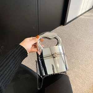 Mini silver cylindrical handbag with mirror finish, featuring an integrated handle and chain