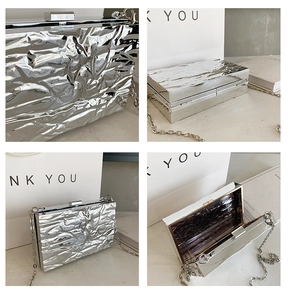 Detailsicht der silbernen Abendtasche mit Faltenstruktur und feiner Metallkette