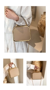 Detail showing octagonal beige handbag with gold metal frame and spiral handle