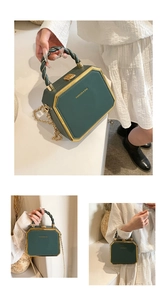 Detail of dark green hexagonal handbag with gold metal frame and woven leather handle