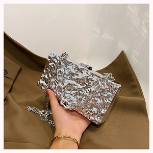 Close-up of silver box clutch bag featuring lava texture and elegant chain strap