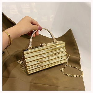 Detailed view of gold rectangle clutch with horizontal stripes and arched metal handle