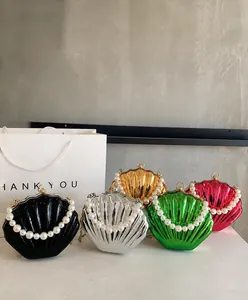 Metallic shell-shaped crossbody bags in multiple colors with elegant pearl handles