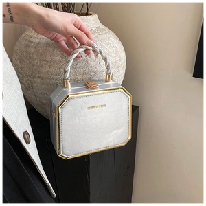 Detail of silver octagonal handbag with gold metal frame and twisted rope handle