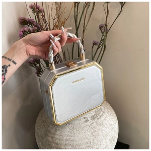 Detail of silver octagonal box bag with gold metal trim and Fashion & Bag text