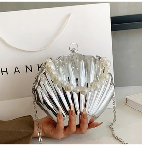 Silver shell-shaped clutch bag with luxury pearl handle and metallic chain strap detail
