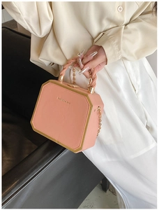Pink octagonal box bag detail with gold metal trim and woven handle