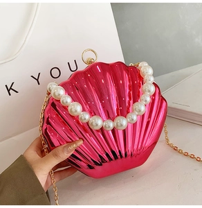 Detail of rose pink shell bag with pearl handle and wavy metallic texture