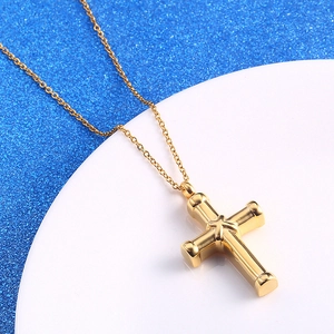 Gold stainless steel cross urn necklace with star engraving on white and blue background