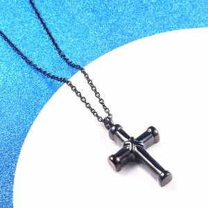 Black stainless steel cross pendant necklace displayed on a blue glitter background