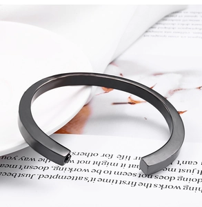 Detailed close-up of a matte black square-cut stainless steel open cuff bracelet