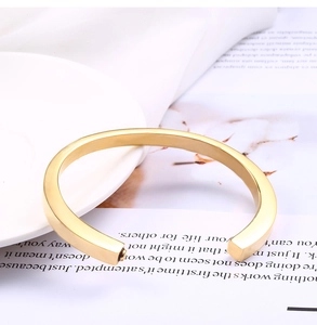 Detail van de minimalistische gouden vierkante geometrische open armband