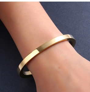 Detailweergave van de gouden minimalistische titanium stalen armband om een pols