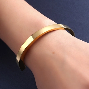 Polished gold stainless steel open bangle bracelet for cremation ashes in minimalist design